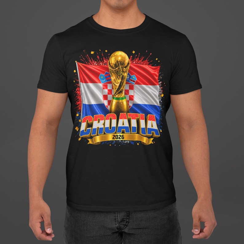 Black t-shirt worn by a male model featuring a Croatia football-themed design with the FIFA World Cup trophy, Croatian flag, and bold “CROATIA 2026” text on the front.