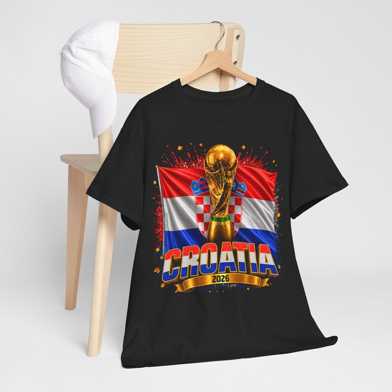 Black t-shirt worn by a male model featuring a Croatia football-themed design with the FIFA World Cup trophy, Croatian flag, and bold “CROATIA 2026” text on the front.