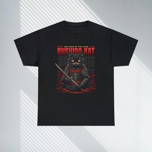 May include: Black t-shirt with a graphic of a black cat dressed as a samurai holding a sword. The text "THE CODE OF THE CLAW" and "BUSHIDO KAT" is printed in red on the shirt.