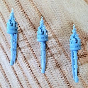 Könnte beinhalten: Drei graue Plastik-Miniaturfackeln mit einem Flammen-Design auf der Oberseite. Die Fackeln sind etwa 10 cm hoch und haben ein detailliertes Design.