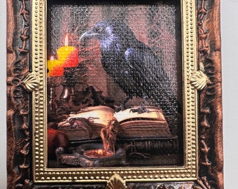 May include: A framed painting of a black raven perched on an open book with a lit candle in the background. The frame is brown with gold accents.