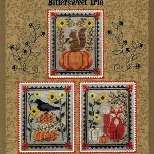 May include: Cross-stitch pattern titled "Bittersweet Trio" featuring three framed designs. One shows a squirrel on a pumpkin, another a crow, and the last a fox. The background is a textured tan color with floral accents.