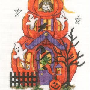 May include: Cross-stitch design of a Halloween pumpkin house with an owl, ghosts, and a witch. The orange pumpkin house has a purple roof, a black fence, and a jack-o'-lantern. The word "BEWARE" is stitched at the bottom.