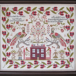May include: Framed cross-stitch sampler with a brown wooden frame. The sampler features a central red brick house, two birds on branches, and floral and foliate borders. Text includes "Rachel Moxwells her Work David and Mary".