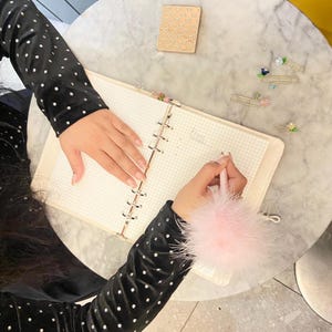 Write like a 90’s Icon with the classic Clueless-inspired fluffy pom pom pen in pink ribbon!