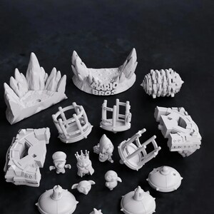 May include: A collection of white 3D-printed figurines and set pieces, including characters, platforms, and architectural elements. The text "MARIO BROS" is visible on one of the set pieces. The figurines include a character wearing a crown.