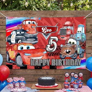 May include: A birthday party scene with a banner featuring Cars characters, the name "Leo", and the number "5". The table is set with a cake, cupcakes, and party favors. Red, blue, and white decorations create a festive atmosphere.