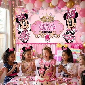 May include: A birthday party scene with a Minnie Mouse theme. The backdrop features Minnie Mouse illustrations and the name "Olivia" with the number "6". Children are gathered around a cake, and the table is set with themed plates and cups.