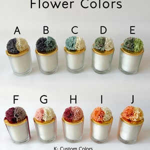 May include: Ten small glass candle jars with gold lids and different coloured flower tops. The flower colours are: A - white and grey, B - grey and white, C - green and white, D - white and green, E - green and white, F - burgundy and grey, G - pink and white, H - burgundy and white, I - orange and white, J - orange and white. The text below the jars reads: "K: Custom Colours (Please specify the colour combination you want in the personalisation section.)"