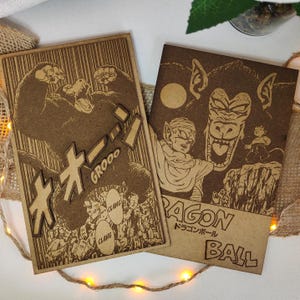 Puede incluir: Dos paneles de madera con tem&aacute;tica de Dragon Ball Z. El primer panel presenta una imagen en blanco y negro de un gran simio con el texto japon&eacute;s "GIGORO" y las palabras "CLANG" y "GROOOO". El segundo panel presenta una imagen en blanco y negro de un gran simio con un personaje de la serie Dragon Ball Z. El texto "DRAGON BALL" est&aacute; escrito en japon&eacute;s e ingl&eacute;s.