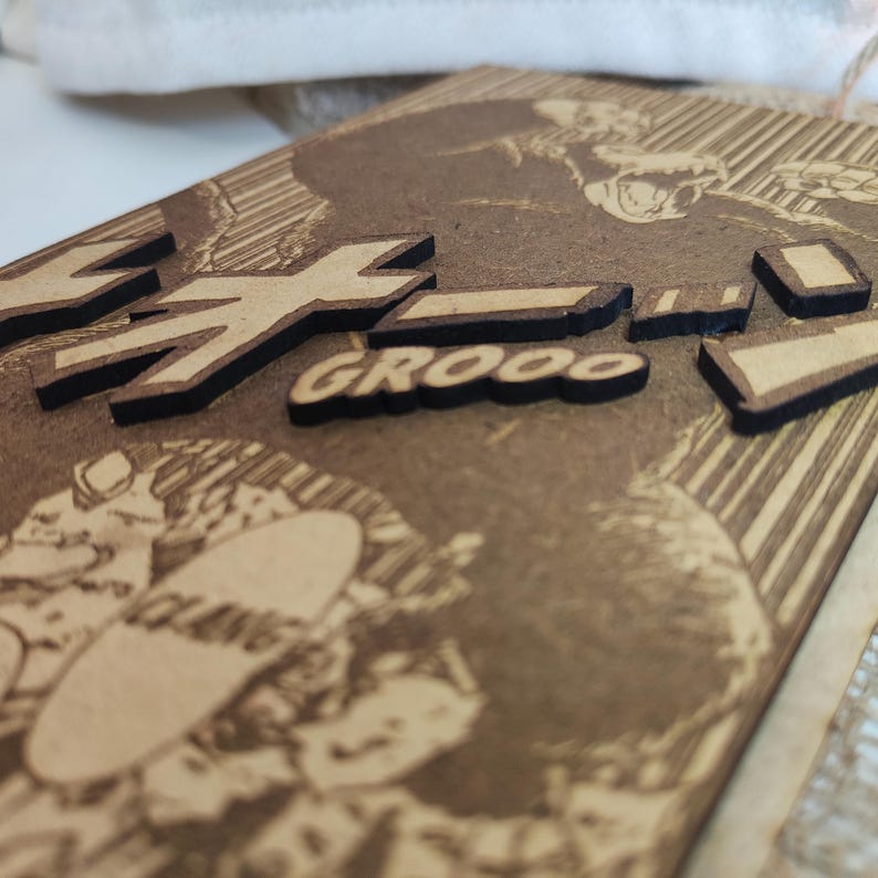 Puede incluir: Un letrero de madera con un gr&aacute;fico en blanco y negro de un personaje de dibujos animados. El letrero tiene el texto "GROOO" y "Z" en letras negras.
