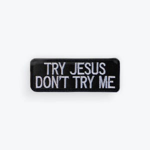 May include: Black rectangular patch with the embroidered text "TRY JESUS DON'T TRY ME" in white. The patch has a rounded border and is likely designed to be sewn or ironed onto clothing or accessories.