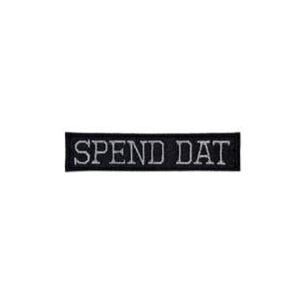 May include: A rectangular black patch with the text "SPEND DAT" embroidered in white. The patch is likely made of fabric and designed to be sewn or ironed onto clothing or accessories.