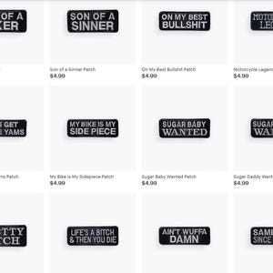 May include: A collection of black rectangular patches with white embroidered text. The patches feature phrases like "Son of a Biker," "Sugar Baby Wanted," and "Same Club Since Day One." These patches are likely for jackets or bags.