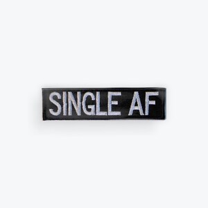 May include: A black rectangular patch with the words "SINGLE AF" embroidered in white. The patch is centered on a white background.