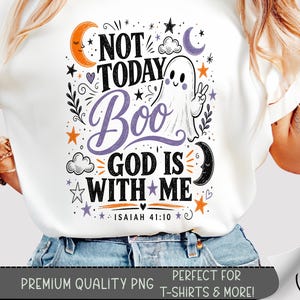 May include: A white t-shirt featuring a graphic design with the text NOT TODAY BOO GOD IS WITH ME and ISAIAH 41:10. The illustration includes a white ghost making a peace sign, orange and purple moons, stars, and clouds in a celestial theme.