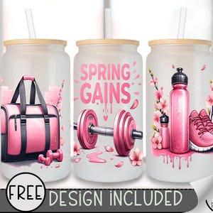 May include: Three pink and white tumbler cups with a straw. The cups have different designs. One cup has a pink gym bag, dumbbells, and pink flowers. Another cup has a pink dumbbell, pink flowers, and the text "Spring Gains". The third cup has a pink water bottle, pink flowers, and pink sneakers.