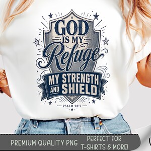 May include: White t-shirt featuring a navy blue and gray graphic design. The design includes the text "GOD IS MY Refuge MY STRENGTH AND SHIELD" within a shield shape, with the scripture reference Psalm 28:7. The bottom of the image reads "PREMIUM QUALITY PNG PERFECT FOR T-SHIRTS & MORE!"