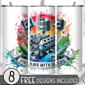 May include: White tumbler featuring a colorful watercolor design of engine parts, including pistons, a motor, and wrenches. The design is set against a vibrant background with the text "STILL PLAYS WITH BLOCKS" on a banner. The bottom of the tumbler has the text "8 FREE DESIGNS INCLUDED".