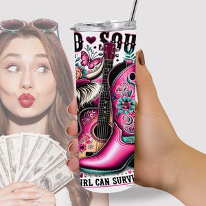 K&ouml;nnte beinhalten: Ein rosafarbener und wei&szlig;er Edelstahlbecher mit einer Grafik einer Gitarre, eines Stiefels und eines Schmetterlings. Der Text "Bad Soul Girl Can Survive" ist auf den Becher gedruckt.
