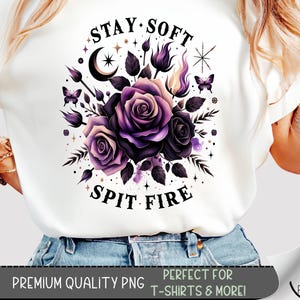 May include: White t-shirt featuring a floral design with purple roses, butterflies, and celestial elements. The text "STAY SOFT SPIT FIRE" is displayed above and below the floral arrangement. The bottom of the image includes the text "PREMIUM QUALITY PNG" and "PERFECT FOR T-SHIRTS & MORE!"