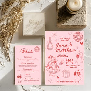 Op de afbeelding: Roze trouwuitnodigingsset met rode illustraties. De uitnodiging luidt: 'We gaan trouwen! Anna & Matthew' met huwelijksdetails. Een bijpassende detailkaart en een decoratieve doos zijn ook zichtbaar.