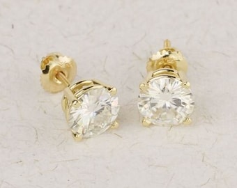 May include: A pair of gold stud earrings with round, clear gemstones.