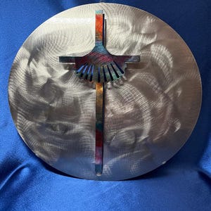 Könnte beinhalten: Eine weiße Keramik-Tasse mit schwarzem Henkel und dem Text "But First, Coffee" in fetter, schwarzer Schrift. Die Tasse steht vor einem verschwommenen Hintergrund, der eine gemütliche Umgebung suggeriert.