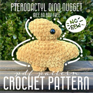 May include: Crochet pattern for a brown, no-sew, crocheted Pterodactyl Dino Nugget. The pattern is available as a PDF download. The image shows the finished crocheted dinosaur toy.
