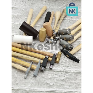 May include: A collection of 12 different hammers and mallets with wooden handles. The hammers have various head shapes and sizes, including round, square, and flat. Some of the hammers have metal heads, while others have wooden or plastic heads.