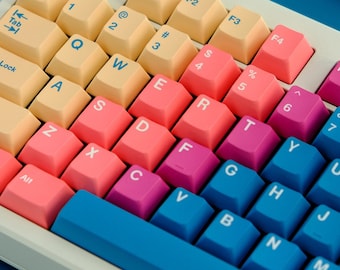 May include: A white keyboard with pastel colored keys. The keys are labeled with letters, numbers, and symbols. The keyboard has a blue space bar and a blue row of keys at the bottom.