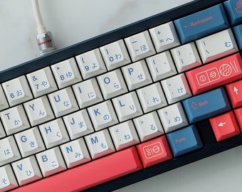 May include: A white and blue mechanical keyboard with Japanese characters on the keys. The keyboard has a red and white space bar and a black frame. The keyboard is connected to a white cable.