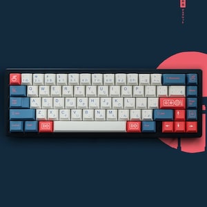 May include: A white and blue mechanical keyboard with Japanese characters on the keys. The keyboard has a black frame and red and blue keycaps. The keyboard is on a blue background.