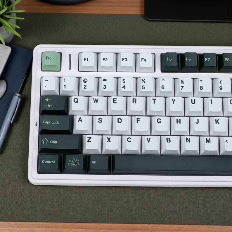 May include: A white mechanical keyboard with light green and dark green keycaps. The keyboard has a standard QWERTY layout with function keys and a control section. The Esc key is light green, and the Shift key is dark green.