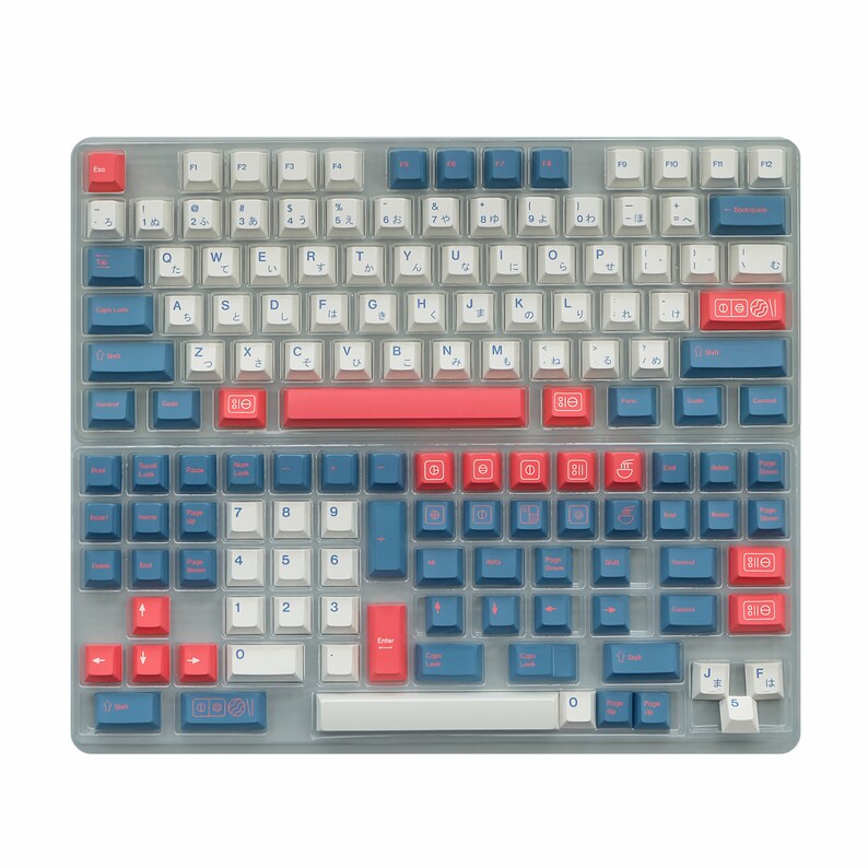 May include: A white keyboard with blue and red keycaps. The keyboard has a Japanese layout with English letters and Japanese characters on the keys. The keyboard has a space bar, a backspace key, a return key, and a number pad.