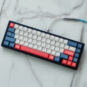 May include: A blue and white mechanical keyboard with red keycaps. The keyboard has Japanese characters printed on the keys.