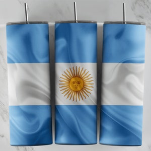 Könnte beinhalten: Drei Edelstahlbecher mit einem blauen und weißen Design, das die Flagge Argentiniens zeigt. Die Becher haben eine goldene Sonne mit einem Gesicht in der Mitte.