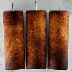 May include: Three stainless steel tumblers with a brown, rusty, distressed, and textured design.