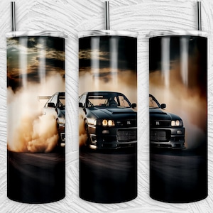 Może przedstawiać: Czarny i srebrny kubek ze stali nierdzewnej z czarnym samochodem dryfującym w chmurze dymu. Samochód ma czarno-białą tablicę rejestracyjną z napisem "R34".