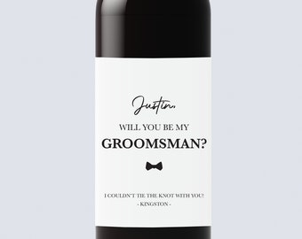 May include: A white wine bottle label with black text that reads "Justin, WILL YOU BE MY GROOMSMAN? I COULDN'T TIE THE KNOT WITH YOU! - KINGSTON -" with a black bow tie icon.