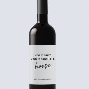Puede incluir: Una etiqueta de botella de vino blanca con texto negro que dice "HOLY SH!T YOU BOUGHT A house CONGRATULATIONS!"