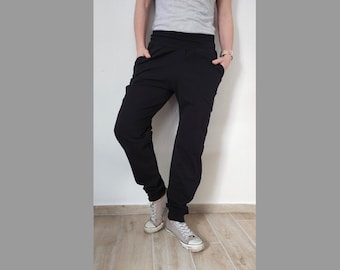 Puede incluir: Pantalón negro de cintura alta y corte holgado. El pantalón tiene una cintura elástica con cordón y dos bolsillos en la parte delantera.