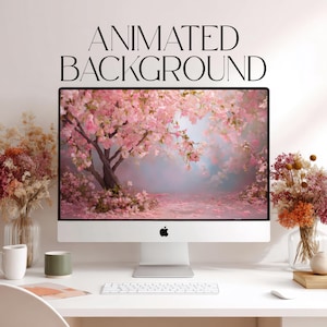 May include: A desktop computer displays a pink cherry blossom scene, with the text "ANIMATED BACKGROUND" above the screen. The computer sits on a white desk, with a keyboard, mouse, and decorative flowers in vases. A mug and a small green cup are also on the desk.