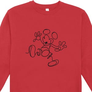 May include: A red sweatshirt featuring a black line drawing of Mickey Mouse. The minimalist design shows Mickey in a playful pose, with his arms outstretched and a cheerful expression. The sweatshirt is a solid red color.