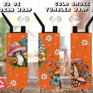 Peut inclure: Trois gobelets orange de 20 oz avec un motif de champignon et de fleurs. Les gobelets sont enveloppés d'un motif représentant un champignon, des fleurs et un visage souriant. Le texte "COLD SMOKE TUMBLER WRAP SET" est en haut de l'image.