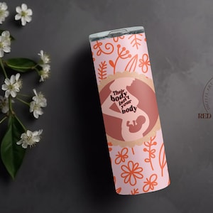 Puede incluir: Un vaso de acero inoxidable rosa y naranja con un patrón floral y una silueta de una mujer embarazada con el texto "Their body isn't your body".
