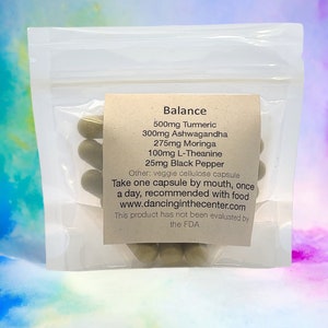 May include: A clear plastic bag filled with green capsules labeled "Balance" with the following ingredients: 500mg Turmeric, 300mg Ashwagandha, 275mg Moringa, 100mg L-Theanine, 25mg Black Pepper. The label also states "Other: veggie cellulose capsule" and "Take one capsule by mouth, once a day, recommended with food www.dancinginthecenter.com This product has not been evaluated by the FDA."