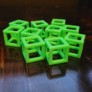 May include: A group of ten bright green, hollow, plastic cubes. The cubes are arranged in a loose, asymmetrical pattern.