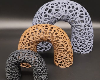 May include: Three decorative arches made of a lattice-like material. The largest arch is light gray, the middle arch is brown, and the smallest arch is black.