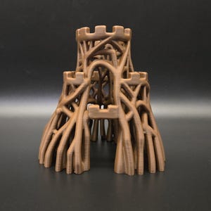 May include: A brown, 3D-printed castle model with three towers connected by a network of branch-like structures. The towers have crenellated tops. The model is set against a dark background.